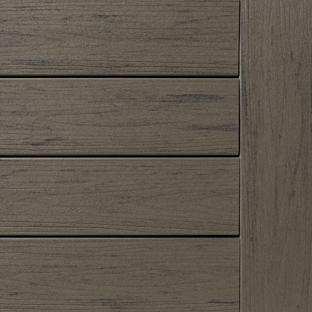 Close-up of Terrain Silver Maple composite decking boards in a grey-brown finish, showing wood grain texture and joint seams.